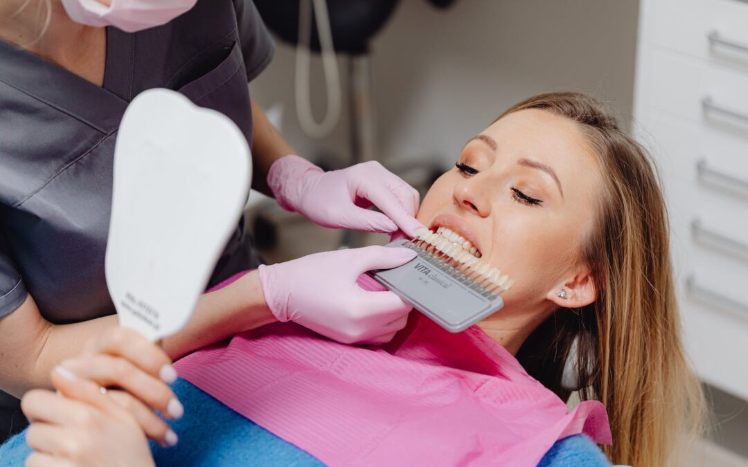 A Dentist Holding a Dental Shade Guide in front of a Patient